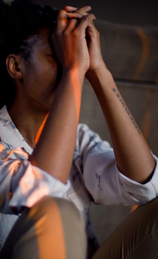 sad woman sitting with hands together covering her face