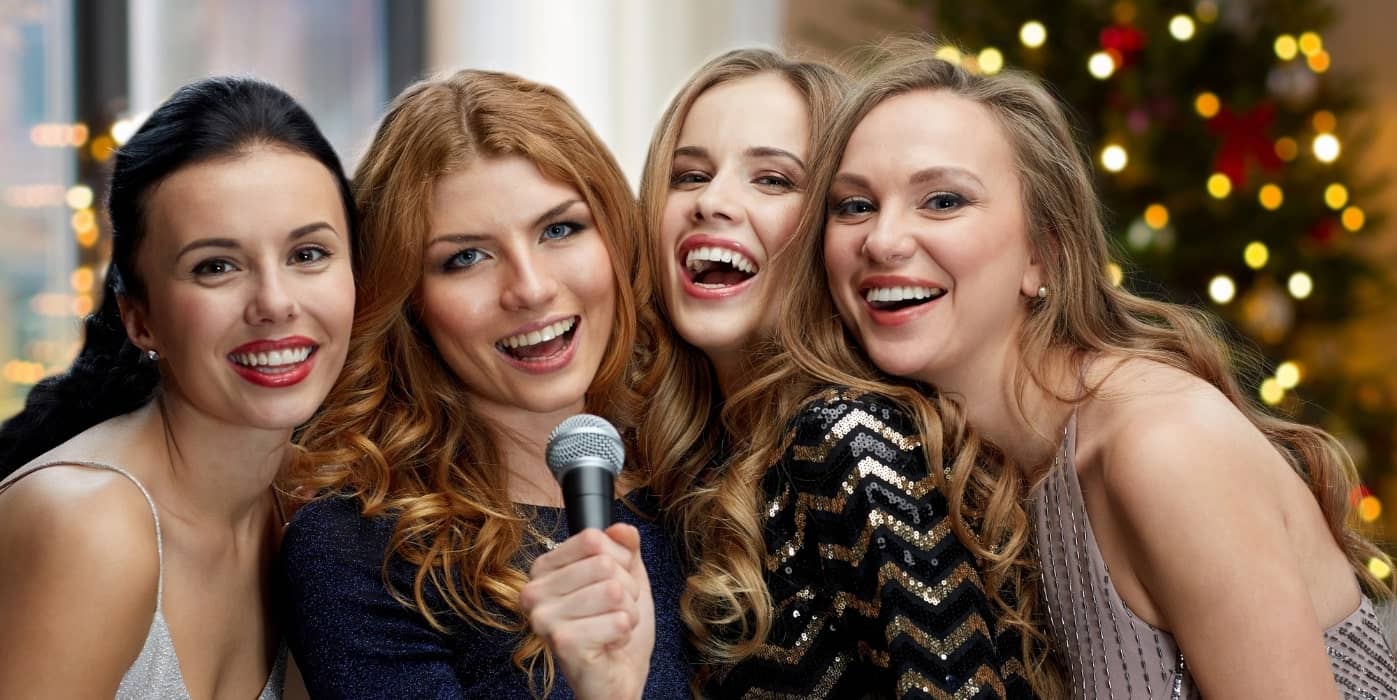 four smiling women standing close to each other