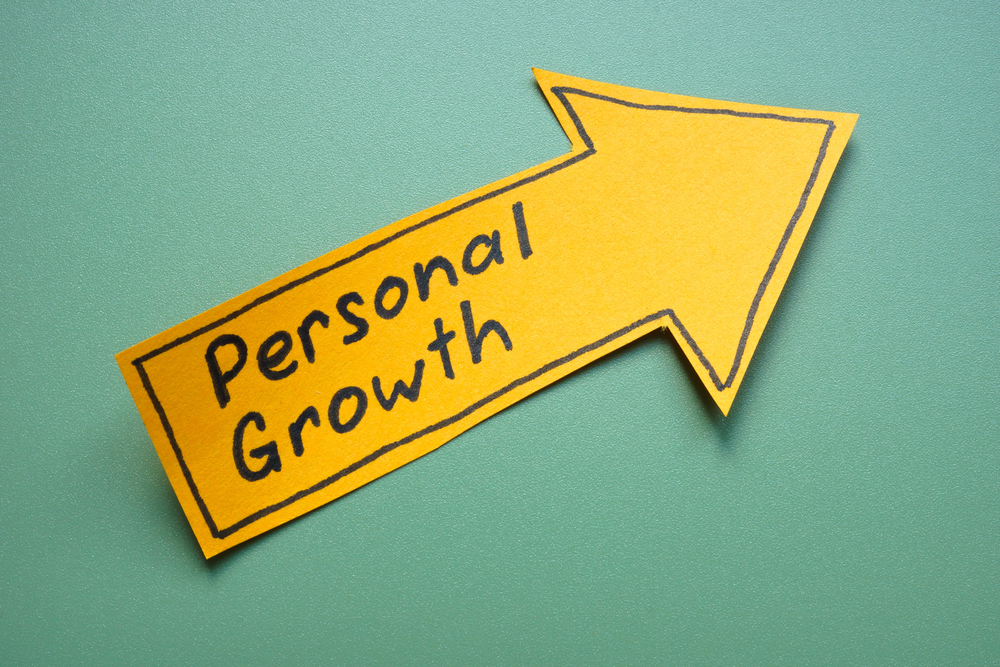 A yellow arrow-shaped note with the words "Personal Growth" on a green background.