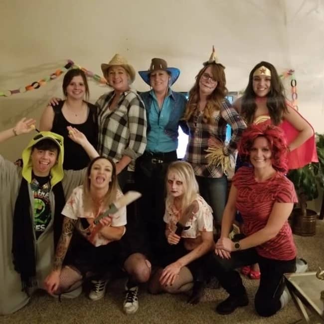 nine people pose in their Halloween costumes