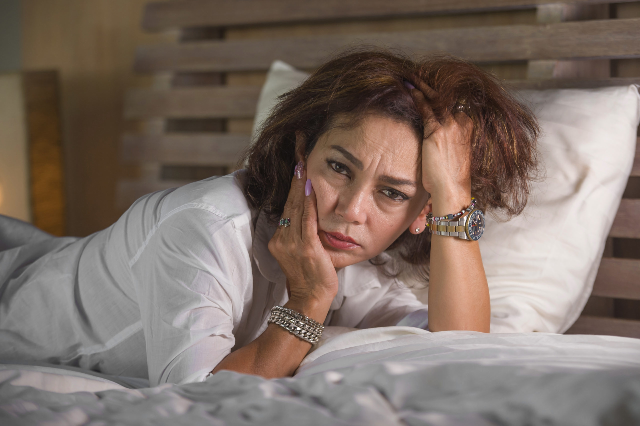 lonely woman lying on a bed