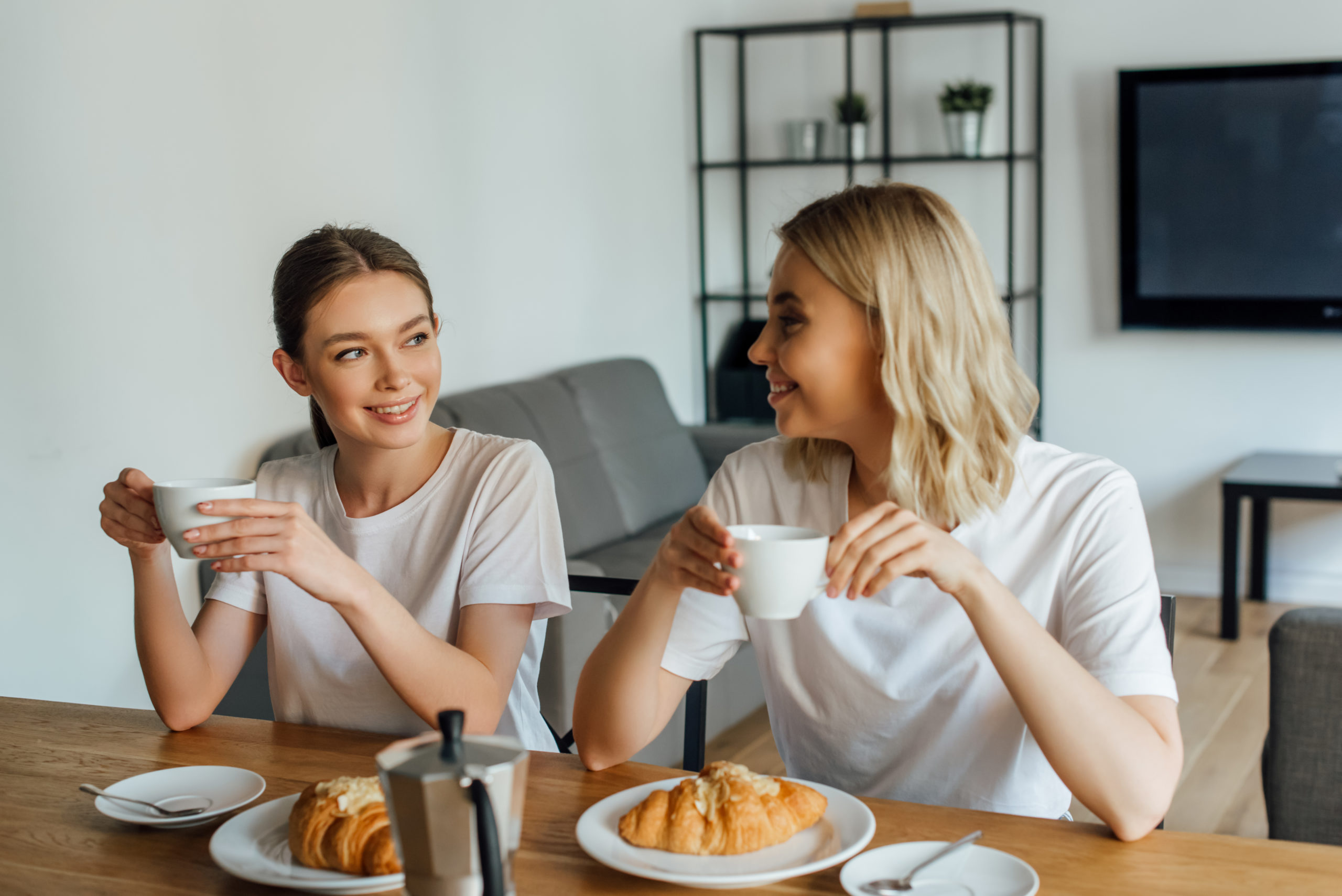 two women having coffee and bread together