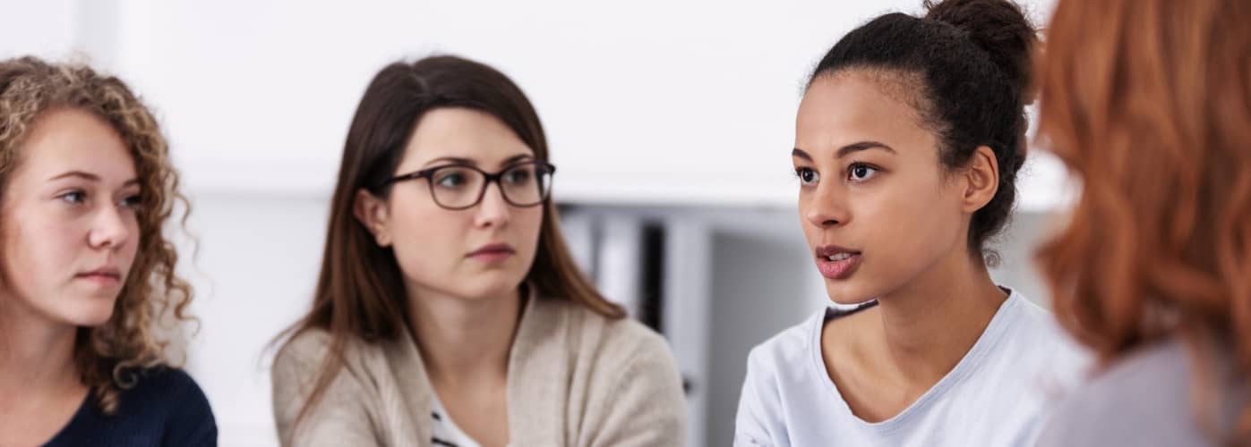 women supporting each other during psychotherapy group meeting