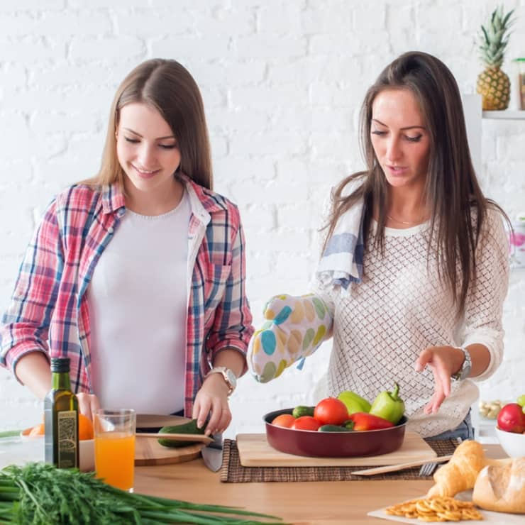 Two girls preparing dinner in a kitchen concept